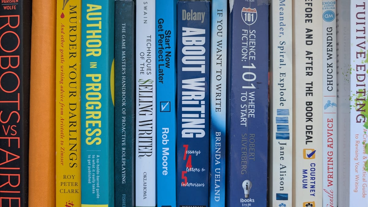 A shelf of book spines shading from orange to blue to white. Most are writing books.