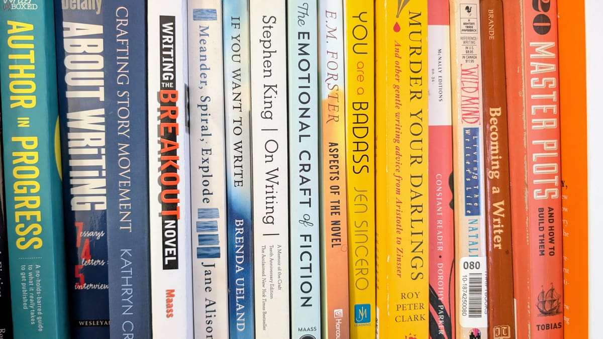 A bookshelf with various writing books in a gradient of blue to white to yellow to orange.